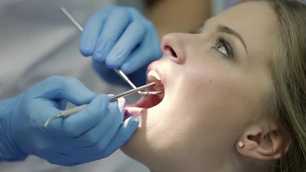 Pretty womans teeth examining in dental clinic - Filmati, video