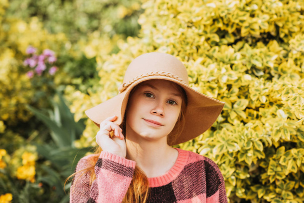 Outdoor close up portrait of pretty young red-haired girl wearing brown hat  - Photo, Image