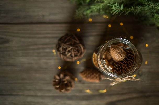 Christmas gift with homemade gingerbread cookies, nuts and chocolates. Glass jar, fir branches, Christmas spices and decor. Winter holidays, New Year or Christmas concept. Top view with copy space. - Foto, immagini