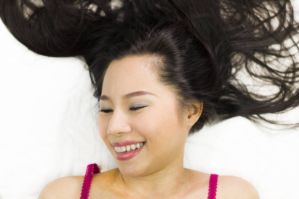 Closeup portrait of happy asian women  lying on ground with blac - Φωτογραφία, εικόνα