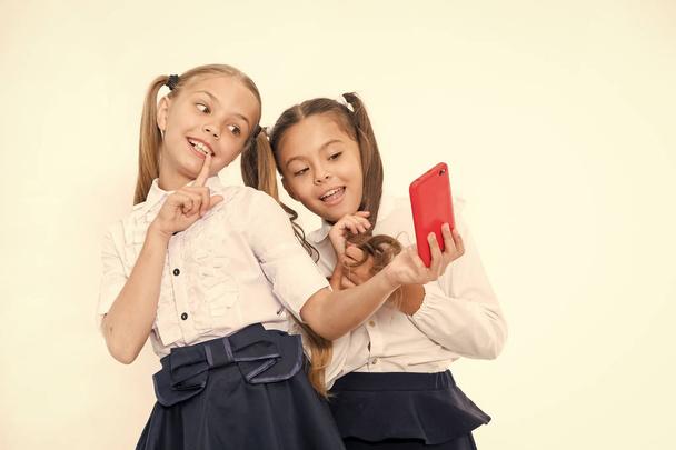 Girls school uniform take selfie smartphone. Posing to take perfect photo. Girlish leisure. Girls just want to have fun. Schoolgirls cute hairstyle use mobile phone or smartphone to share photos - Foto, afbeelding