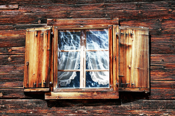 Janelas com cortinas e persianas em uma velha casa de madeira
 - Foto, Imagem