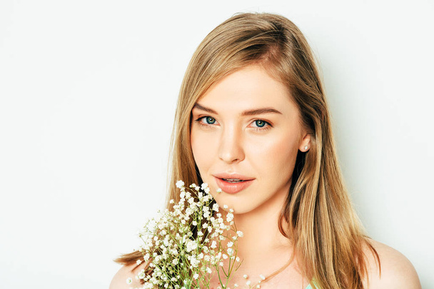 Close up portrait of beautiful young woman with blond hair and nude make up, holding Gypsophila (Baby's-breath) flowers - Zdjęcie, obraz
