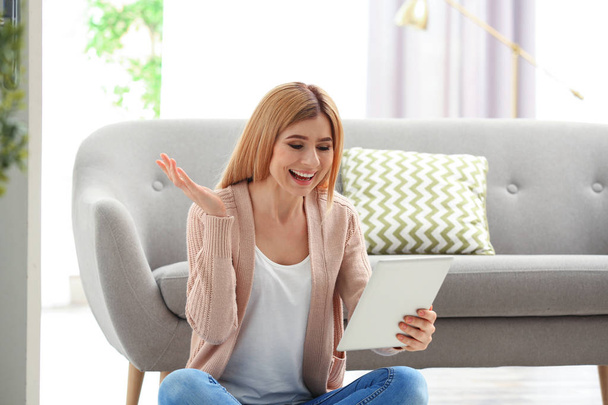 Woman using tablet for video chat in living room - Foto, Imagem