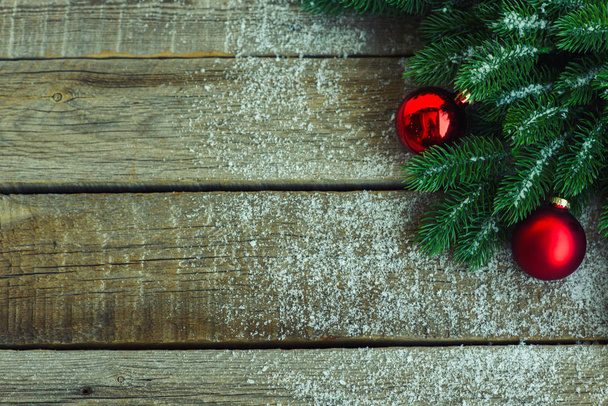 Різдвяний фон для вітальних листівок з гілками ялинки, прикрасами та червоними кульками на дерев'яній дошці. Вид зверху з пробілом для копіювання тексту
. - Фото, зображення