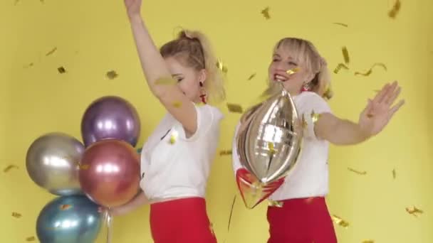 Happy girls having party and dancing on yellow background - Video
