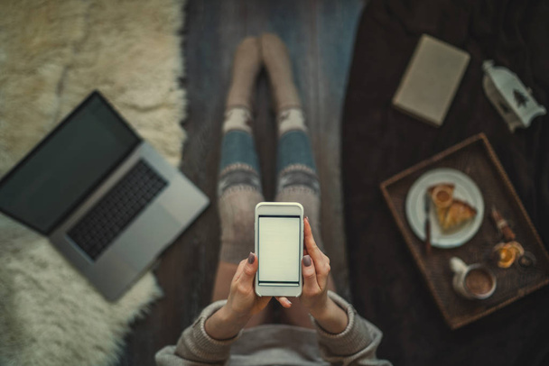 Woman using smartphone for browsing internet store at home. Online shopping conceptspace for text. Mood winter. Seasonal holidays. Merry Christmas and New Year. Top view. Toned image. Selective focus. - Fotoğraf, Görsel