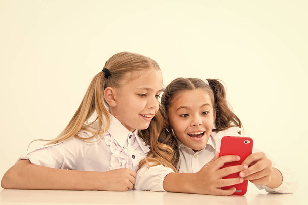 Modern life concept. Little children girls study smartphone as integral part of modern life. little girls with cell phone. - Фото, изображение