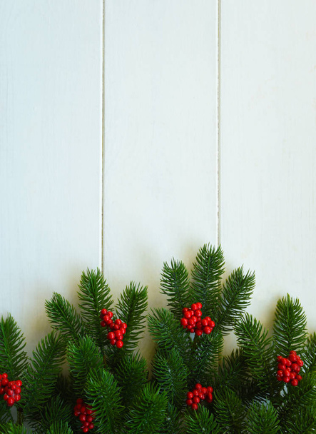 Christmas background for greeting card with Christmas tree branches, decoration and red balls, on on wooden board. Top view with copy space for text. - Fotografie, Obrázek
