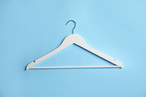 Empty wooden clothes hanger on color background, top view - 写真・画像