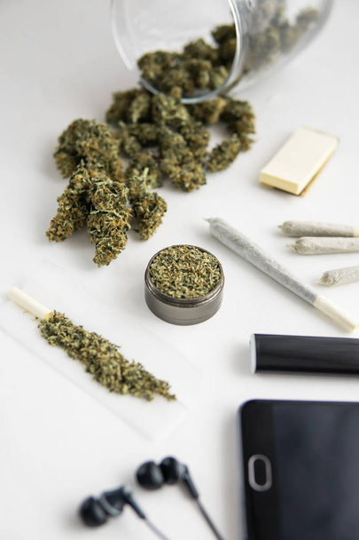 junção com maconha, moedor com erva fresca, botões de Cannabis na mesa preta, close-up, tiro vertical
 - Foto, Imagem
