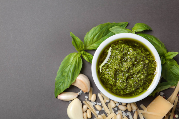 Flat lay composition with pesto sauce and ingredients on grey table. Space for text - Foto, Imagem