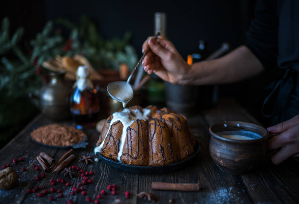 Cooking homemade cake Christmas Eve at home rustic kitchen. Woman's hands make pudding. Ingredients for cooking christmas baking on dark wooden table. Merry Christmas and Happy Holidays! Toned image. - 写真・画像
