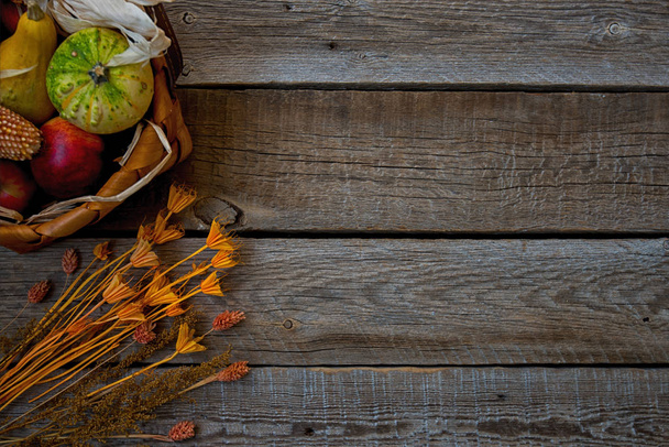 ヴィンテージの木製の背景の秋の収穫のカボチャ。バスケット カボチャ、リンゴと flovers と秋の組成物。有機の野菜。コピー スペース感謝祭有機食品の背景. - 写真・画像