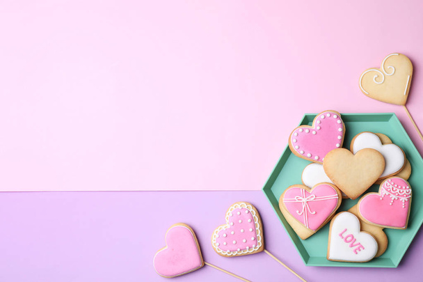 Platte lay compositie met hartvormige cookies op kleur achtergrond. Ruimte voor tekst - Foto, afbeelding