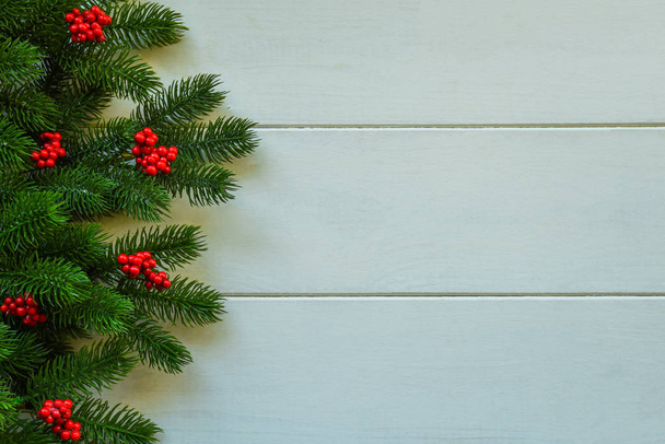 Karácsonyi fából készült hátteret fenyő és piros bogyós gyümölcsök. Megtekintés a másolási térközzel. - Fotó, kép