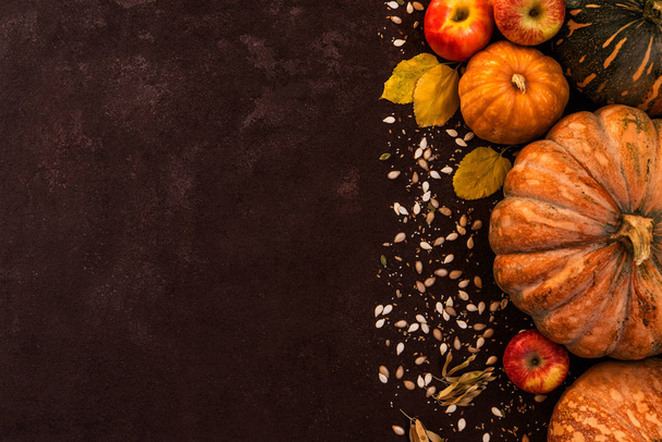 Autumn background with yellow leaves, red apples and pumpkins. Border of fall harvest on aged wood with copy space. Mockup for seasonal offers and autumn food, Top view with copy space. Toned image. - Photo, Image