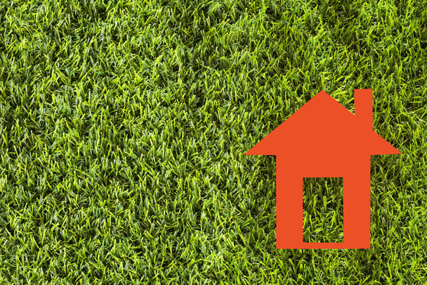 Paper house on green grass - Ecological concept. Top view - Fotografie, Obrázek