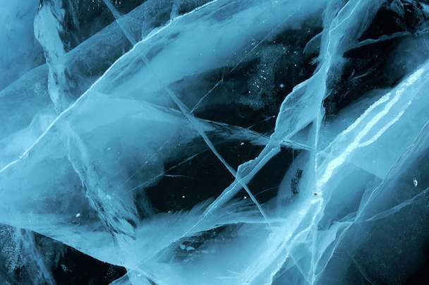 太陽の光線はバイカル湖の透明な氷によって屈折されます。異なる深さで亀裂は奇妙なウェブを作成します - 写真・画像
