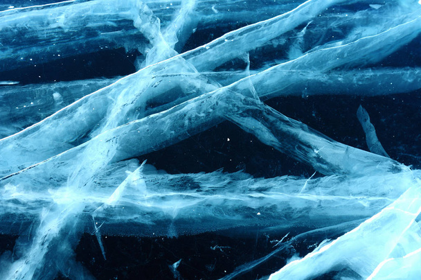 Zonnestralen worden geredigeerd door het transparante ijs van het Baikalmeer. scheuren op verschillende diepten creëren een bizarre Web - Foto, afbeelding