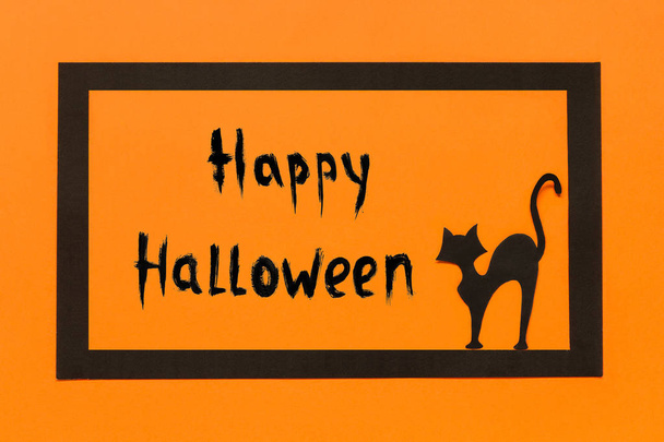 Halloween background. Black paper cat text Happy Halloween in black frame on orange background - Fotoğraf, Görsel