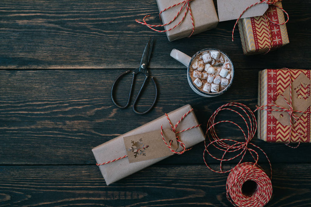 Celebratory Christmas and New Year's holidays background. Gift boxes wrapped craft paper with twine, decorations and spice on the wooden rustic background. Copy space for you text. - Foto, Imagen