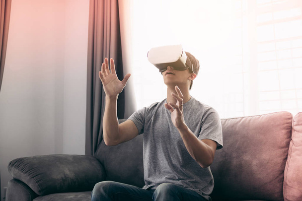 Mladý asijský muž, který nosí brýle ve virtuální realitě v obývacím pokoji f - Fotografie, Obrázek