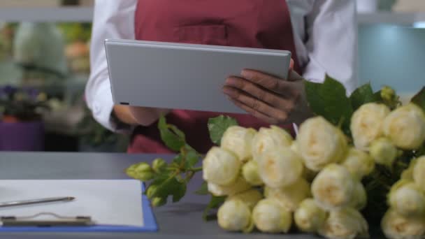 Femme fleuriste mains en utilisant tablette pour prendre des commandes
 - Séquence, vidéo