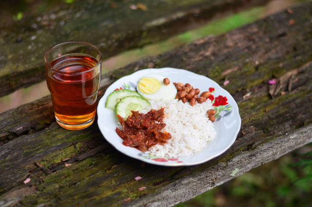 Malajské tradiční jídlo "Nasi Lemak", které slouží na rustikálním dřevěném stole. Pohled shora. - Fotografie, Obrázek