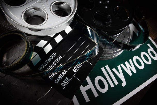 Film reel and clapboard. Hollywood, entertainment industry background on a wood table - Photo, Image