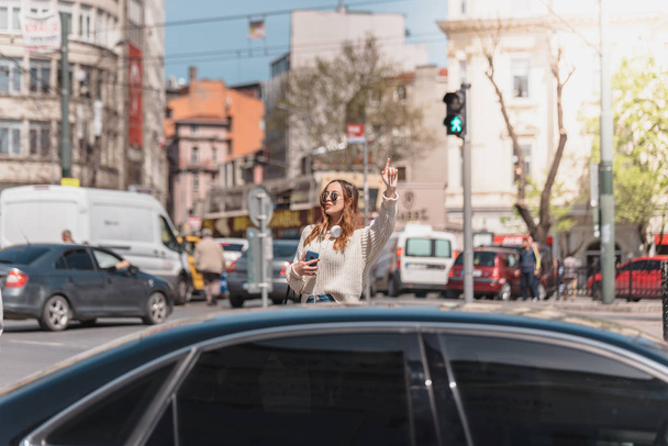 Όμορφη γυναίκα ψάχνει για ένα ταξί στο δρόμο - Φωτογραφία, εικόνα