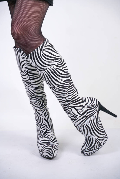 bottes de velours zèbre de mode avec des talons hauts sur fond de studio blanc
 - Photo, image