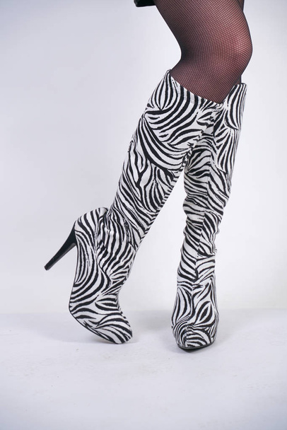 bottes de velours zèbre de mode avec des talons hauts sur fond de studio blanc
 - Photo, image
