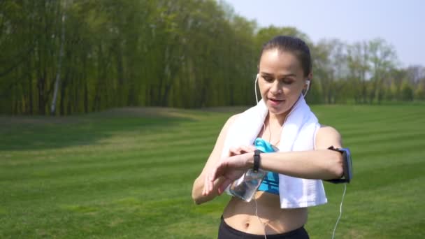 4k. 大人の幸せなフィットネス女性ランナーは、トレーニングを終了し、水を飲みます - 映像、動画