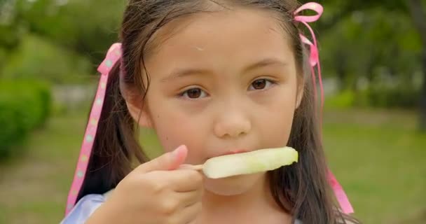 glückliches kleines Mädchen isst Eis am Stiel zur Sommerzeit - Filmmaterial, Video