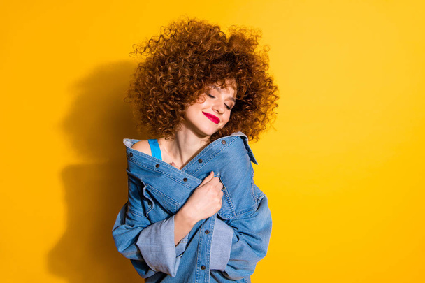 Close-up portrait of her she nice cute lovely charming attractive winsome sweet cheerful wavy-haired girl covering cosy jacket isolated over bright vivid shine yellow background - Foto, Imagem