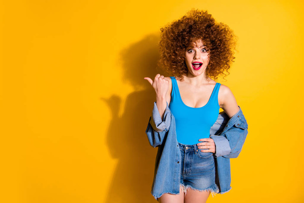 Portrait of her she nice cute lovely winsome fascinating charming attractive cheerful wondered stunned wavy-haired girl pointing aside ad advert isolated over bright vivid shine yellow background - Fotó, kép