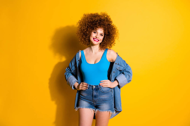 Close up photo beautiful amazing she her lady wavy fluffy styling curls hands arms sides ready party wear casual jeans denim shirt shorts blue tank top outfit clothes isolated yellow bright background - Foto, immagini