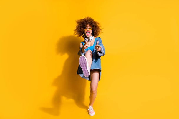 Full length body size photo funky funny she her lady wavy styling clubber strange moves fingers direct wear ear flaps specs casual jeans denim shirt shorts tank top clothes isolated yellow background - Φωτογραφία, εικόνα