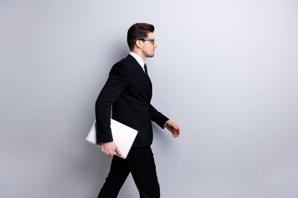 Profile side view portrait of his he nice imposing elegant classy chic attractive confident guy carrying in hands laptop marketing vacancy recruiting office startup isolated over light gray background - Fotografie, Obrázek
