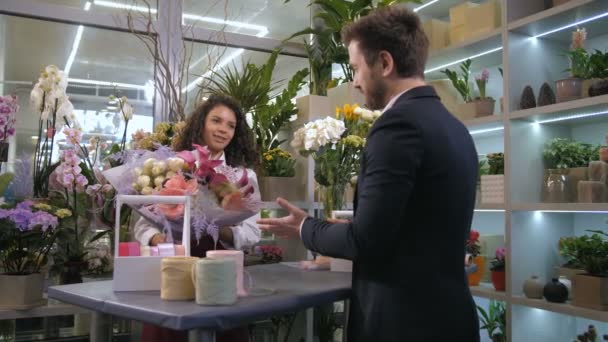 Ανθοπώλης δίνοντας έτοιμο floral δημιουργία σε πελάτη - Πλάνα, βίντεο