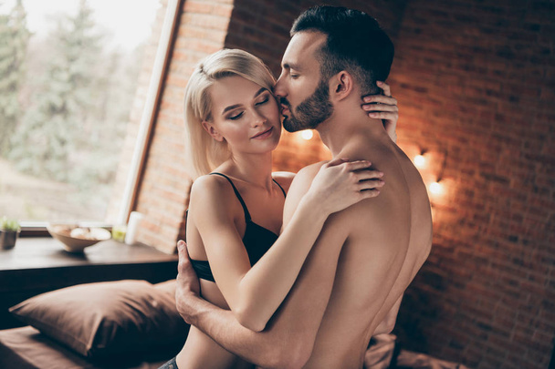 Profile side view portrait of nice charming attractive gorgeous stunning lovely lovable lady cuddling masculine macho guy harmony idyllic affair in loft brick industrial style interior room house - Foto, afbeelding