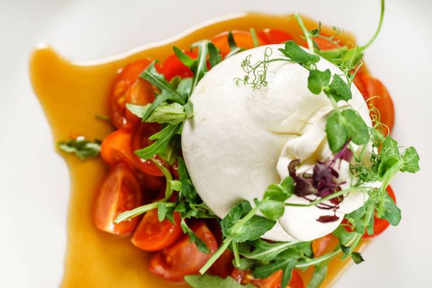 mozzarella and tomatoes on the white plate, close up - Foto, imagen