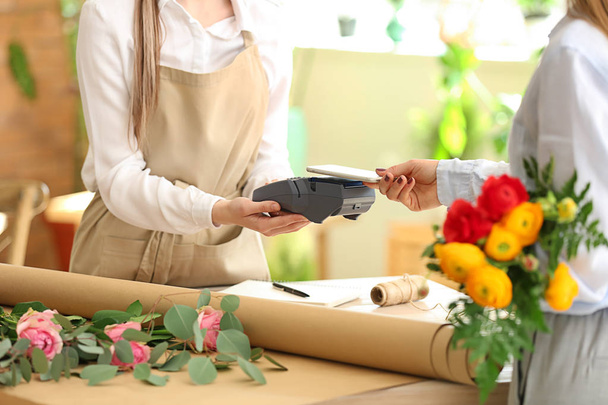 Donna che paga per l'ordine nel negozio di fiori
 - Foto, immagini