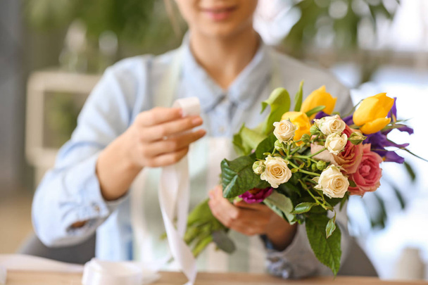 Флорист делает красивый букет в магазине
 - Фото, изображение