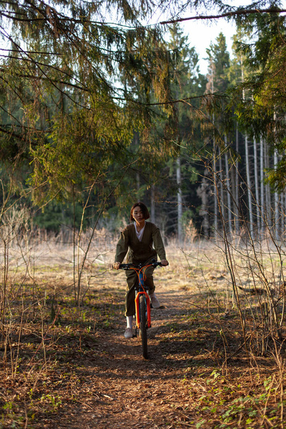 girl on a bike in the forest - Foto, Imagen