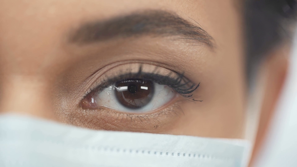 vista de cerca de la mujer afroamericana en máscara médica mirando a la cámara
 - Metraje, vídeo