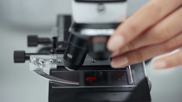 rajattu näkymä tiedemies laittaa näytteen verta mikroskoopilla
 - Materiaali, video