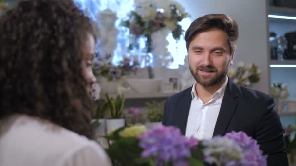 Stylowy klient kwiaciarni wybiera zakład na prezent - Materiał filmowy, wideo