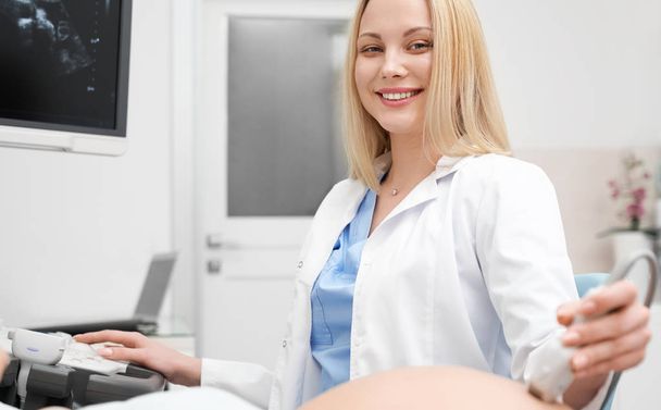 Front view of female doctor doing ultrasound procedure - Foto, Imagen